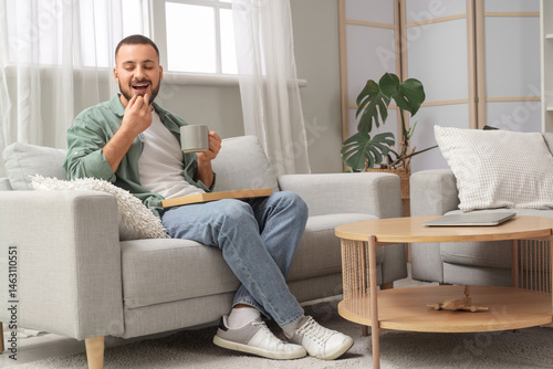 Young man with cup of tea e...