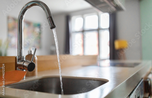 фотографія Close up shot of modern kitchen faucet with water running from tap, flow falling
