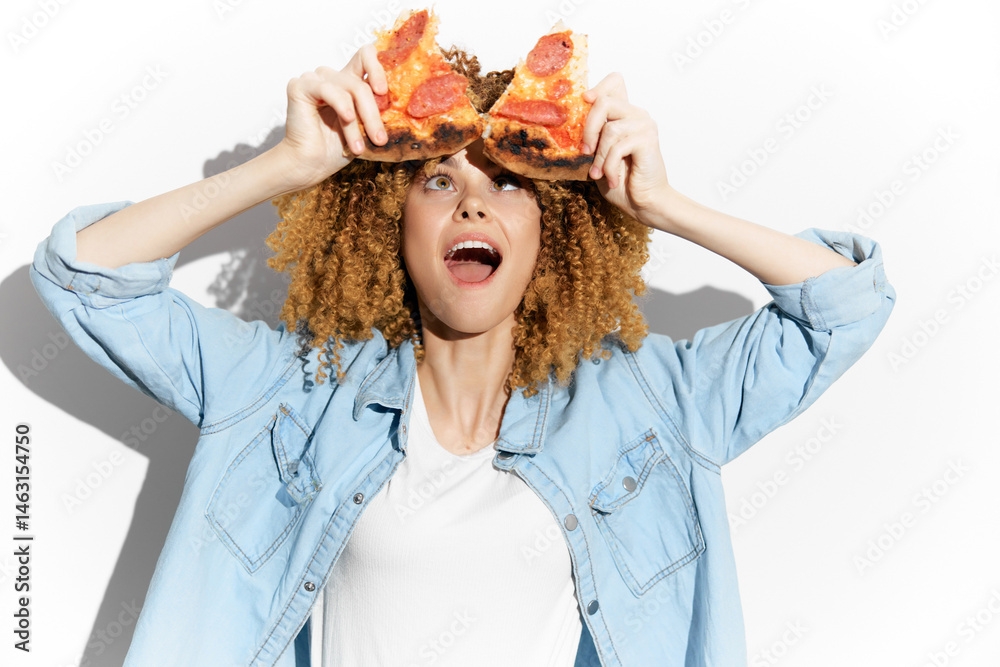 Young woman with curly hair joyfully holding pizza slices, expressing excitement against a white background, perfect for food and lifestyle concepts