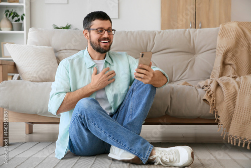 Surprised young man using m...