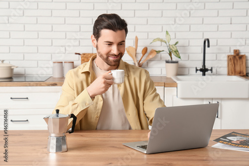Young man with laptop drink...