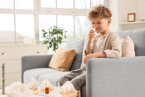 Sick little boy using nasal...