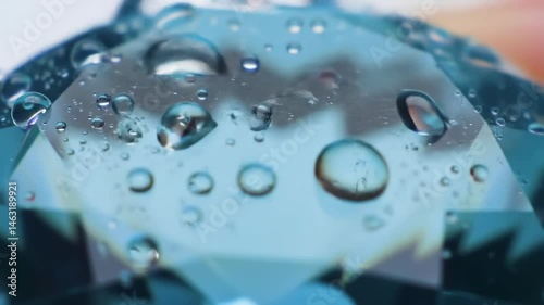Close-up of water droplets on a smooth surface reflecting light, creating a serene atmosphere