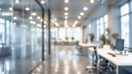 Blurry view of modern office space with desks, chairs, and glass partitions