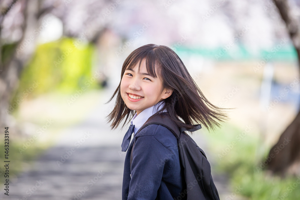 桜の下で微笑む学生