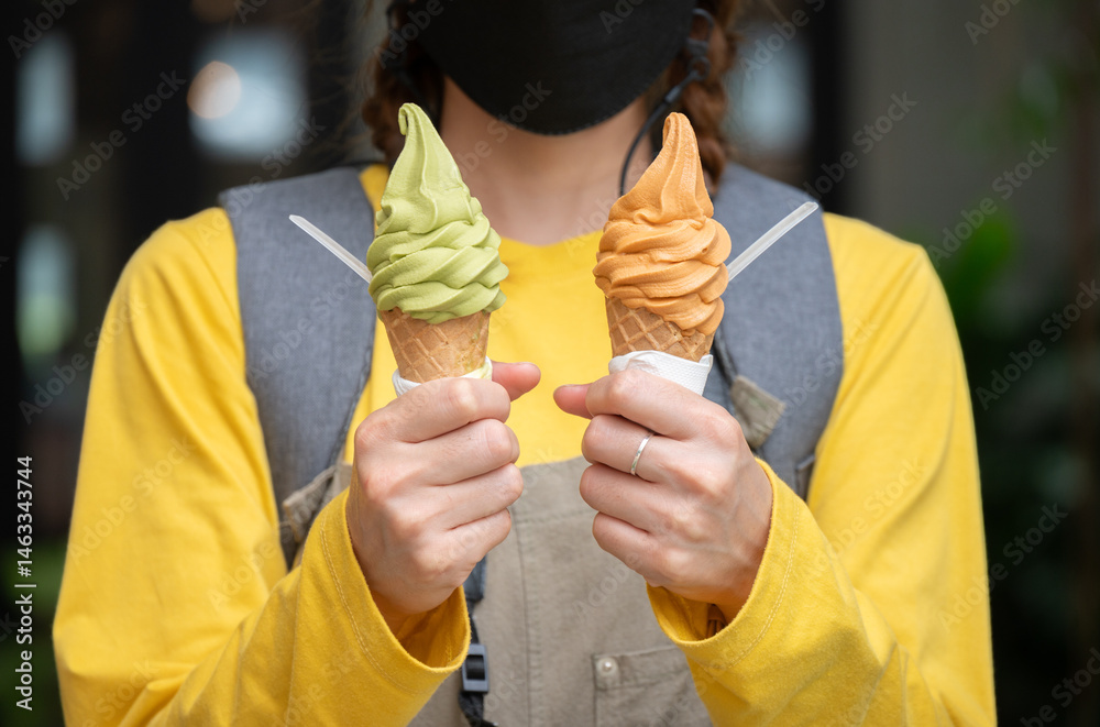 Cropped shot view of woman holding an ice cream. Ice creams are dairy-based frozen foods usually consumed as snacks or desserts.