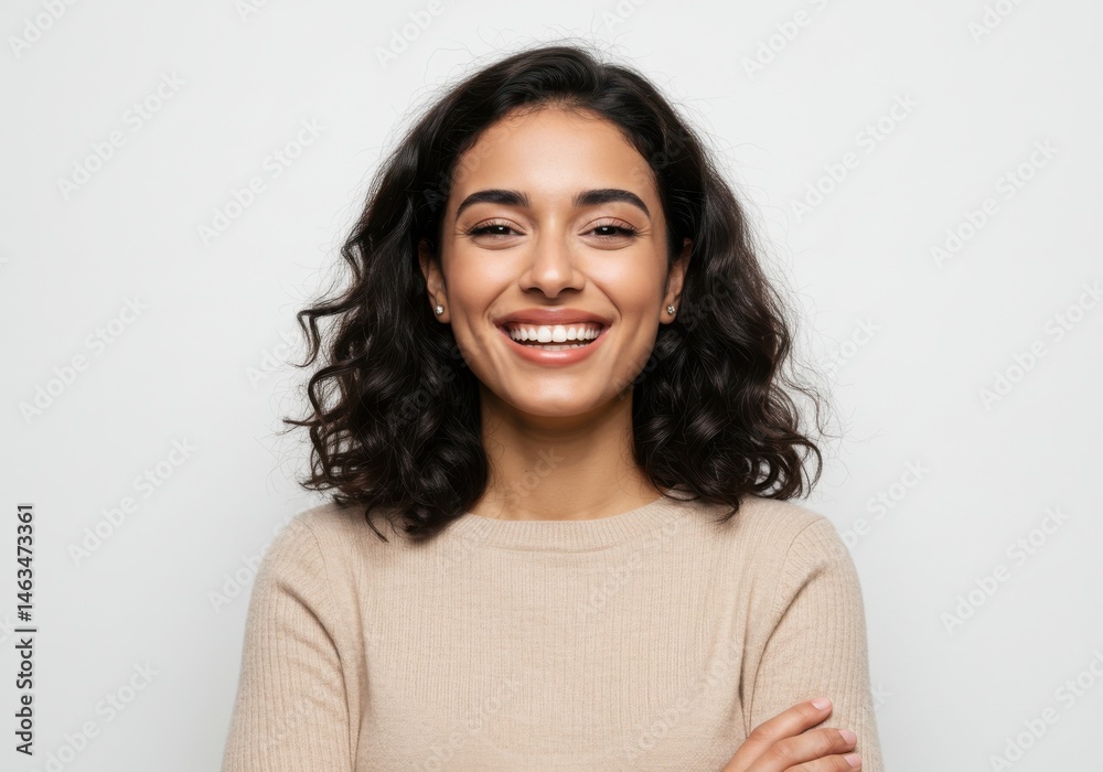 Portrait of a smiling woman with dark curly hair and beige sweater isolated on white background Portrait of a smiling woman with dark curly hair and beige sweater isolated on white background