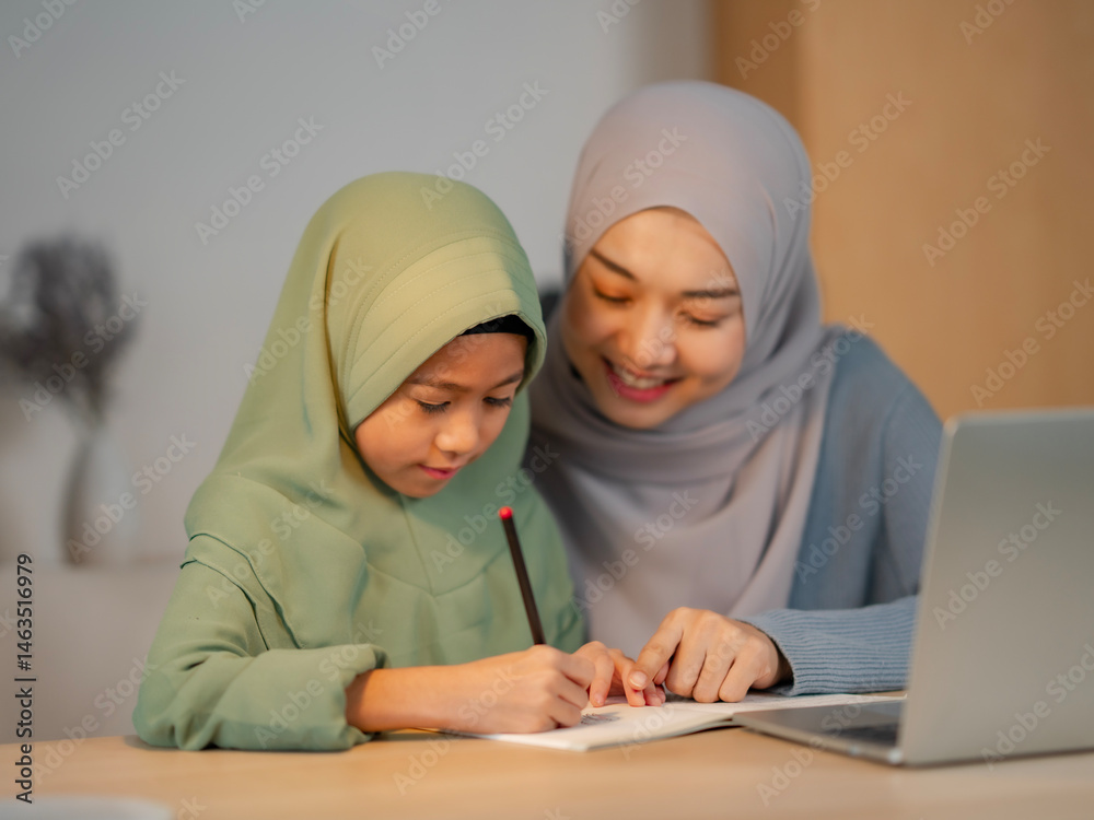 Home education scene with a smiling woman assisting a young girl who is writing in a notebook and learning from a laptop. Cozy, well-lit room reflects modern education and family connection. Home education scene with a smiling woman assisting a young girl who is writing in a notebook and learning from a laptop. Cozy, well-lit room reflects modern education and family connection.