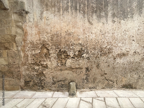 Strada di paese con muro rovinato