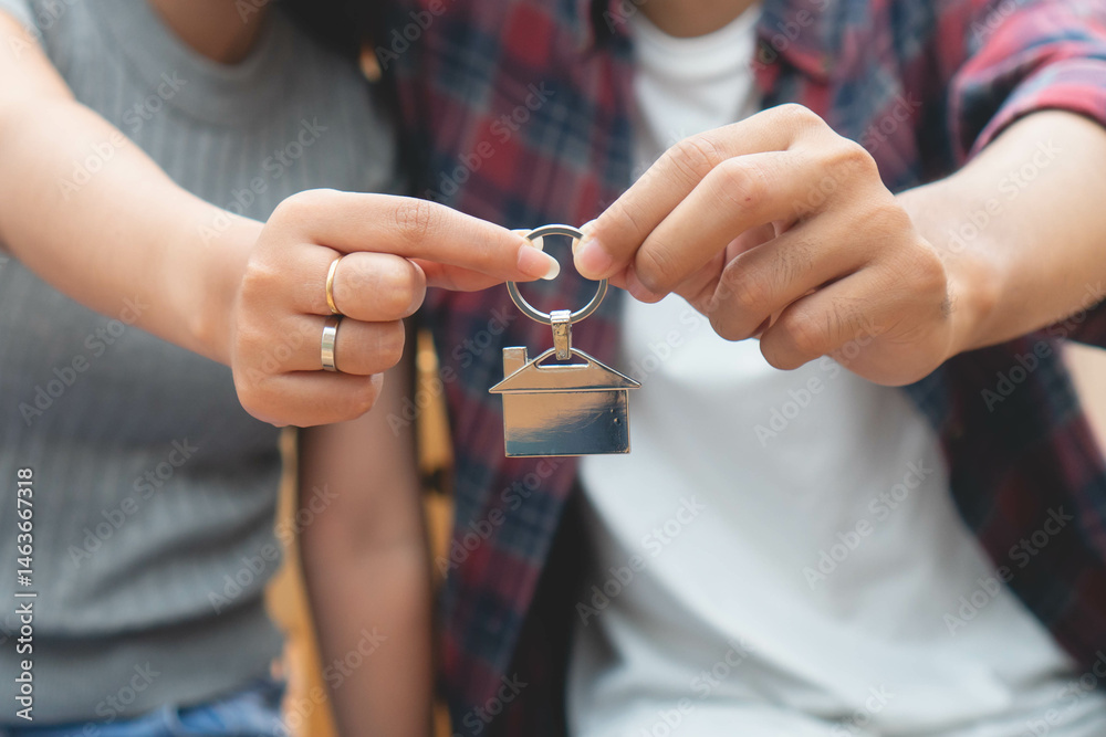 Fototapeta premium Young couple holding a house key after buy new home