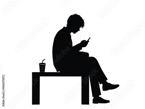 silhouette of a man sitting while playing with a smartphone