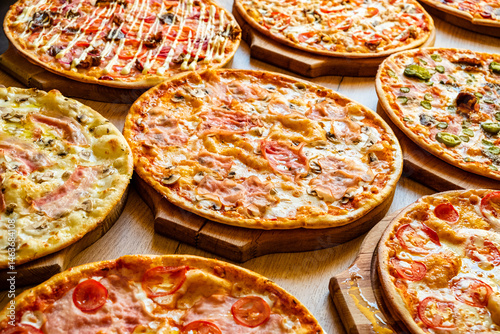 Fotografie An inviting display of multiple pizzas with vibrant toppings, perfect for sharin