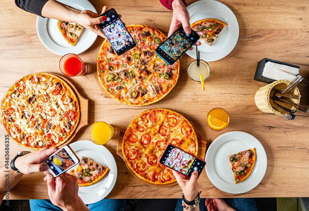 Φωτογραφία Friends savor tasty pizzas and capture memories at a vibrant gathering over shar