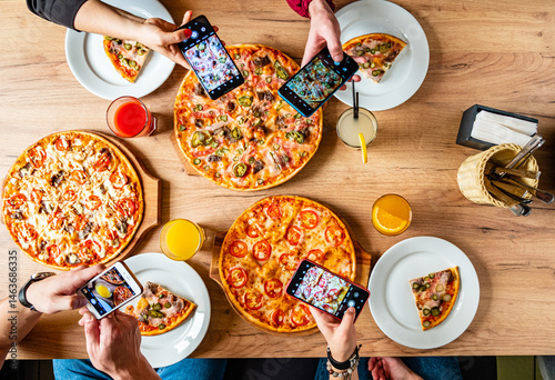 Friends savor tasty pizzas and capture memories at a vibrant gathering over shared joy