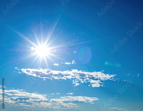 A bright sun shines in a clear blue sky, surrounded by wispy clouds, creating a serene and uplifting atmosphere