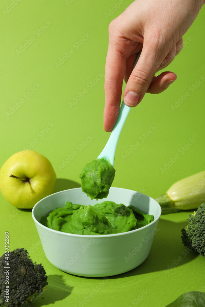 Children's vegetable and fruit puree, on a green background.