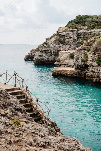 Stone steps leading to turquoise waters, Cala en Brut, Menorca