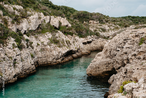 Rocky cliffs and turquoise waters of Cala en Brut, Menorca