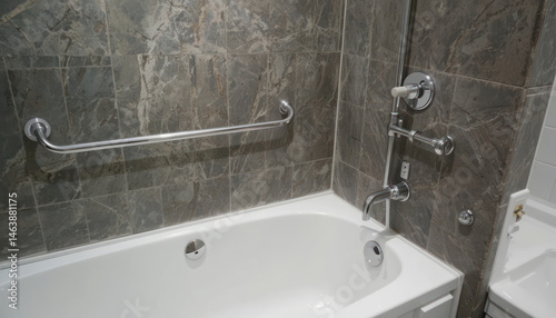Modern Bathroom with Elegant Stone Tile and Clean White Bathtub, Featuring Grab Bars and Sophisticated Fixtures for Safety and Style