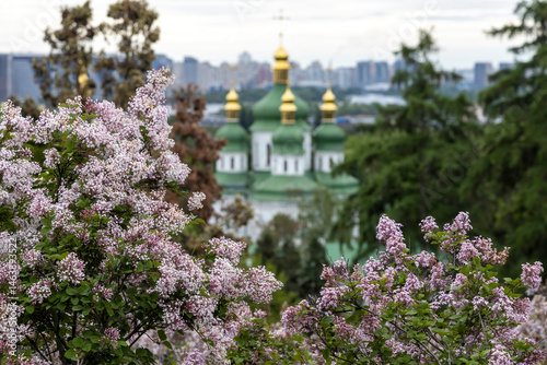Lilac blossom framing green domed Orthodox church Kyiv