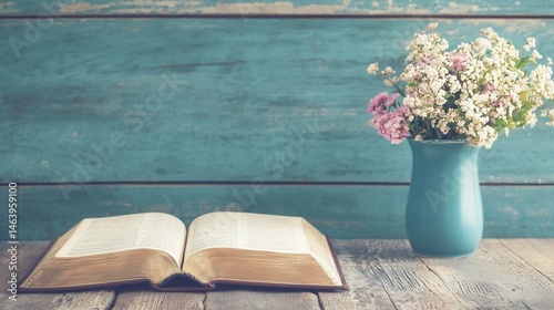 Open Book with Flowers in Vase on Wooden Table