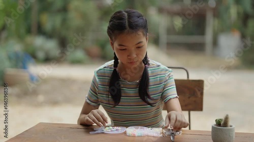Asian girl making handmade necklace accessories