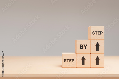 Fototapeta Naklejka Na Ścianę i Meble -  The word step by step on wooden cubes. Achievement or progress in business career. 3d render
