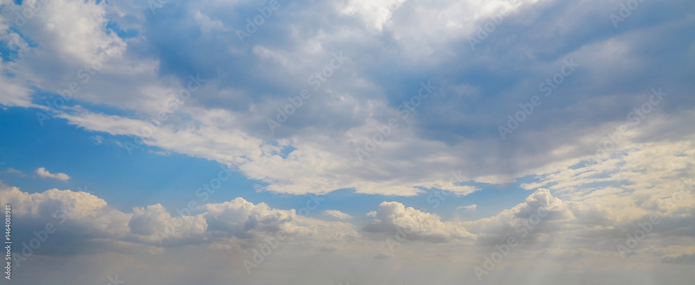 Obraz premium White cumulus clouds in a blue haze in the sky, high clouds soaring in the sky to the horizon, cloud texture in the blue sky as a background.