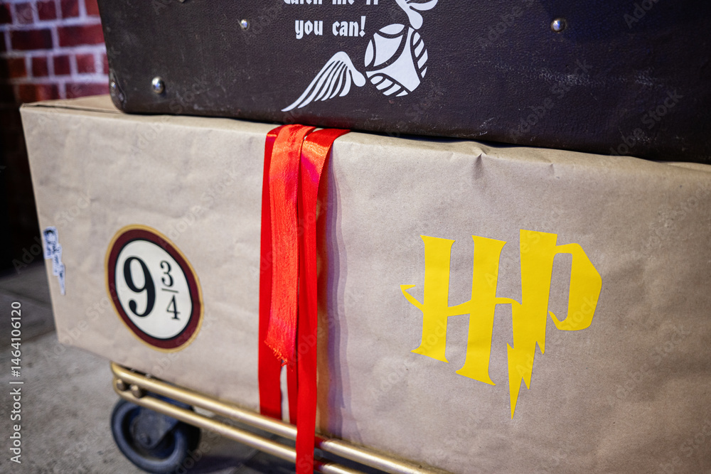 Naklejka premium Colorful luggage Harry Potter themed for fictional magical adventure on a trolley cart
