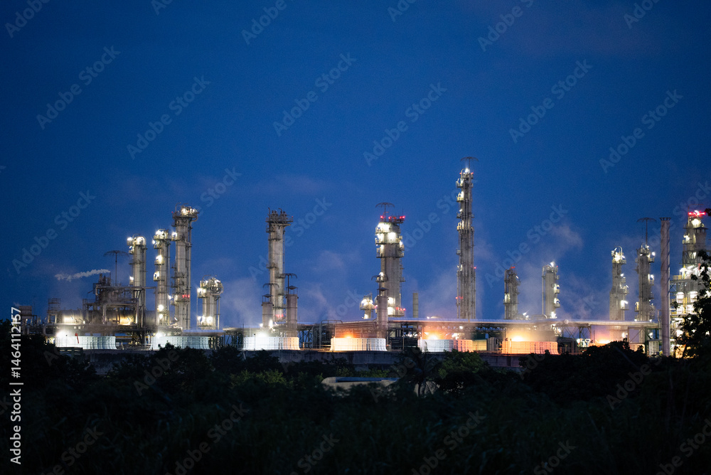 Obraz premium Background of a petrochemical and refinery oil industrial at night view, distillation column, drum and pipeline. Gas, diesel and chemical business