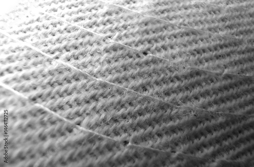 Patterned Fabric with Visible Threads and Gradient Lighting: Woven material with diagonal lines, transitioning from a bright upper corner to a darker lower section