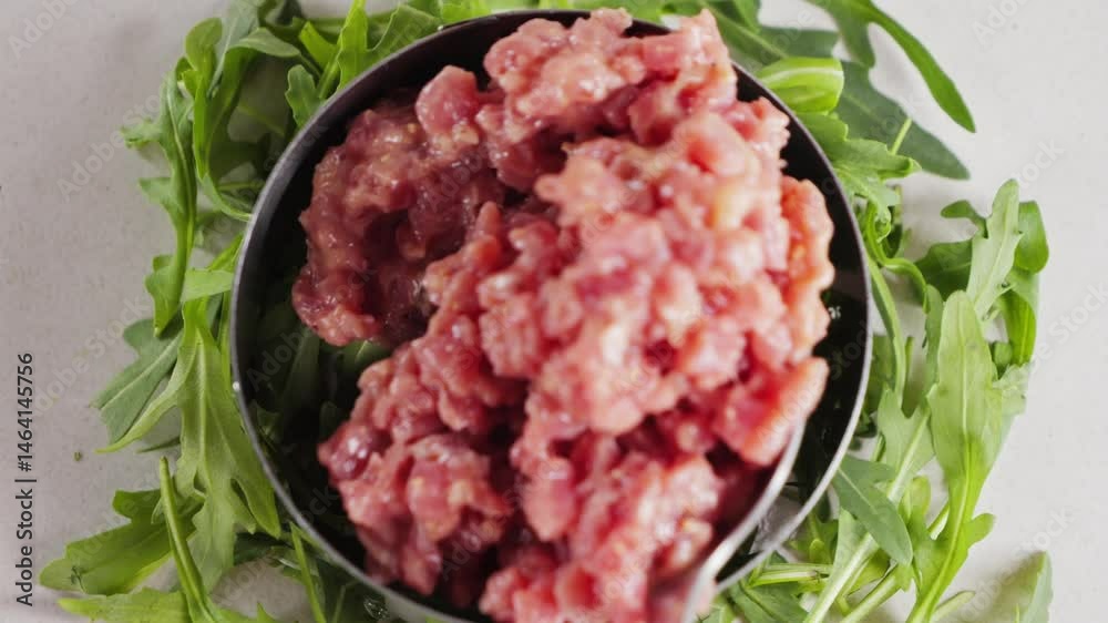 Arranges the diced raw beef using a metal ring mold on a plate, preparing an elegant dish steak tartare. High quality 4k footage