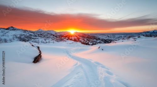 A stunning winter sunrise casts golden hues over a vast expanse of snow-covered mountains, evoking feelings of tranquility and awe in the beauty of nature's winter wonderland.