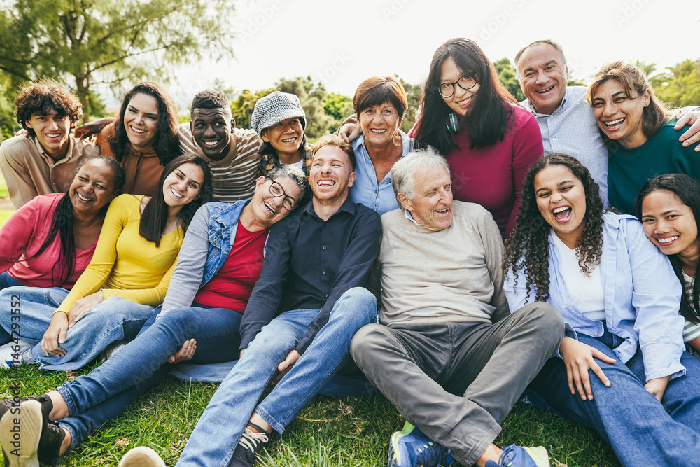 Obraz premium Group of multigenerational people smiling in front of camera - Multiracial friends of different ages having fun together - Main focus on senior center man face