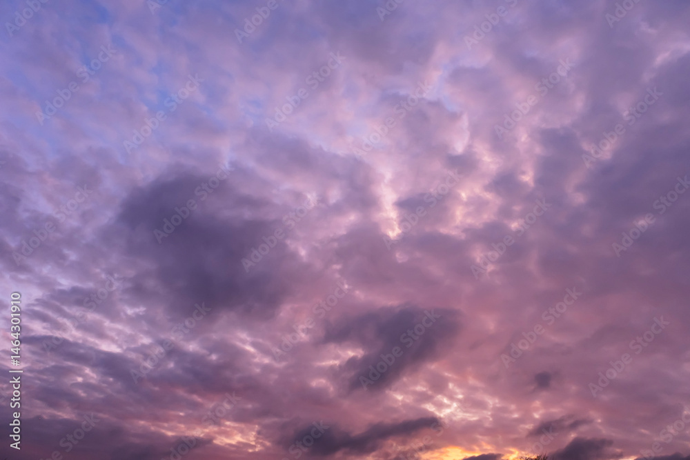 Fototapeta premium Stunning dramatic sunset background with lilac purple clouds and blue sky firmament texture