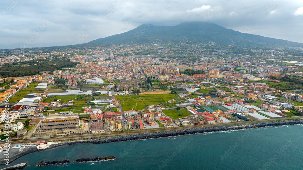 Fototapeta premium Aerial view of the modern city of Herculaneum, in the province of Naples, Italy. The city is a resort and the starting point for excursions to Vesuvius volcano. In foreground is the Mediterranean sea 