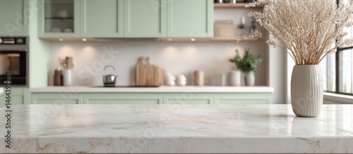 Obraz na płótnie Modern kitchen with mint-green cabinets, marble countertop, and a vase with dried flowers in natural light. w salonie
