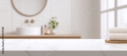 Obraz na płótnie Minimalist bathroom with marble countertop, folded towels, round mirror, and soft natural light. w salonie