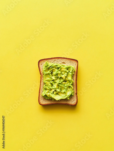 Obraz na płótnie smashed avocado on toasted slice of sandwich bread, empty background, top view, yellow background w salonie