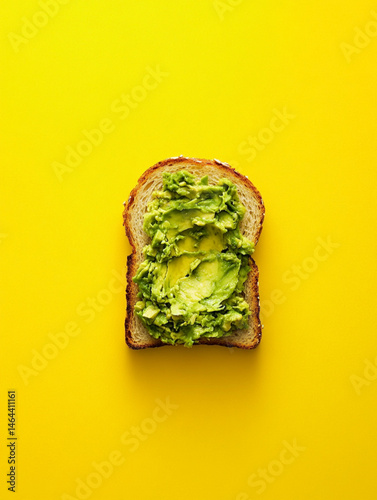 Obraz na płótnie smashed avocado on toasted slice of sandwich bread, empty background, top view, yellow background w salonie