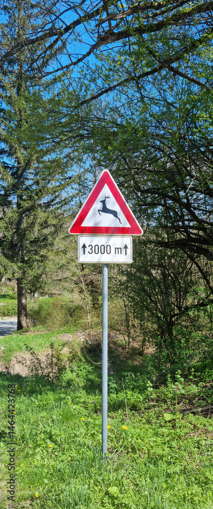 A triangular warning road sign