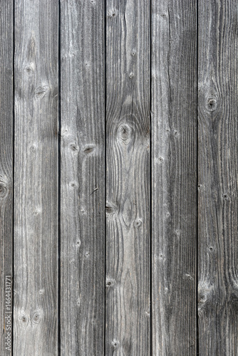 Obraz na płótnie A close-up shows a textured surface of weathered, gray wooden planks arranged vertically with visible grain and knots w salonie