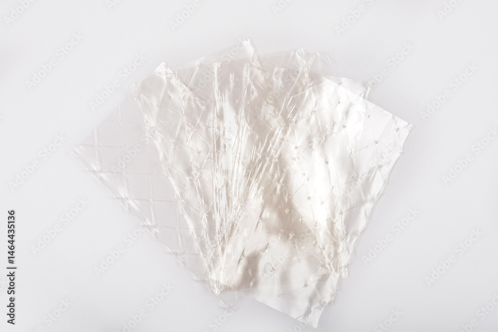 Several translucent sheets of leaf gelatin are slightly overlapping on a light gray background