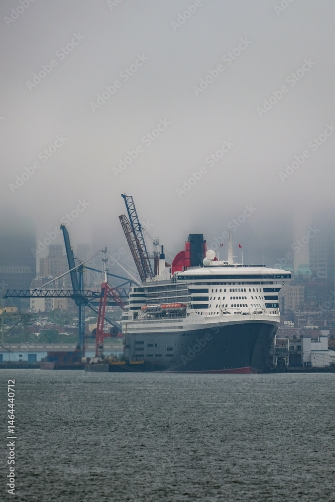 Luxury ocean liner cruiseship cruise ship Queen Mary docked at terminal in Brooklyn on grey rainy cloudy misty day after Transatlantic Crossing in New York City