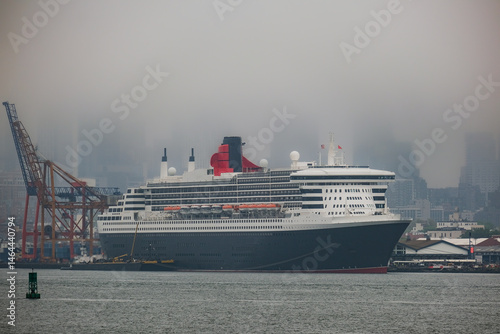 Luxury ocean liner cruiseship cruise ship Queen Mary docked at terminal in Brooklyn on grey rainy cloudy misty day after Transatlantic Crossing in New York City