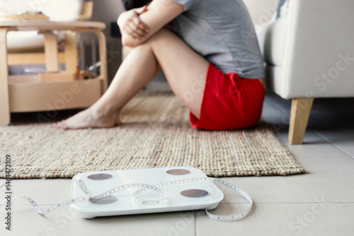 White scale and depression and sad woman sit on the ground and upset for weight loss fail