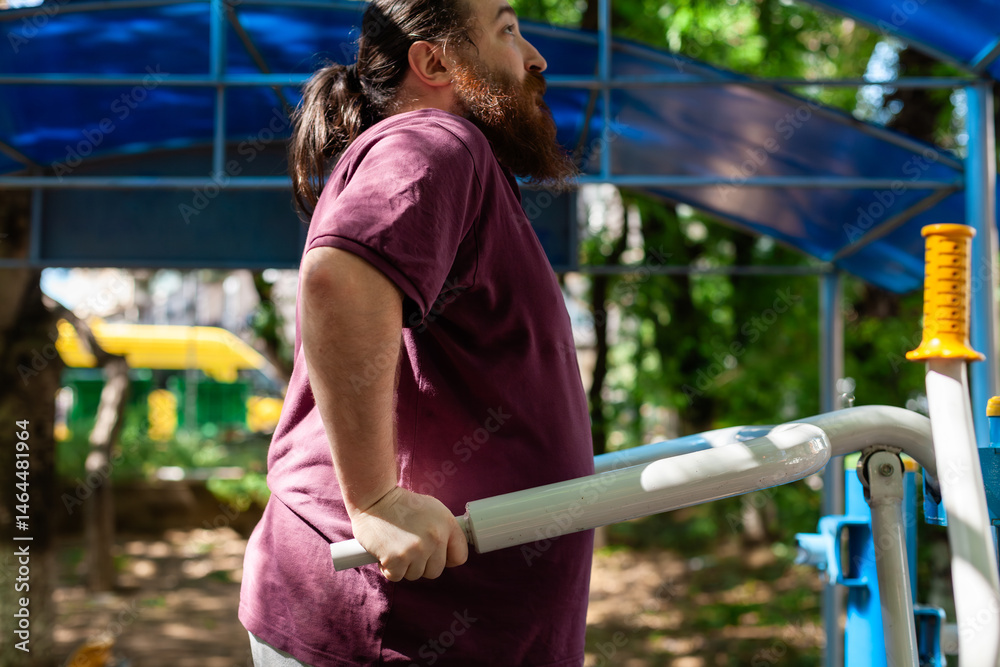 Fototapeta premium Plus-size man exercising outdoors: stretching, using resistance bands and public gym equipment with confidence and joy in spring weather