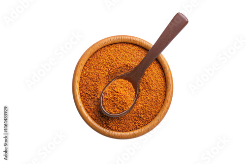 A bowl filled with ground spice and a spoon resting inside.