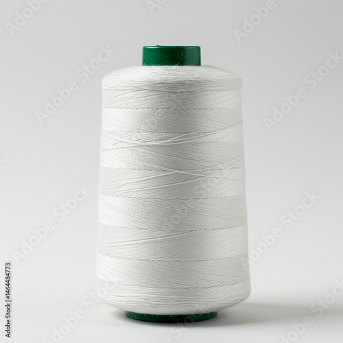 Close-up of a spool of white sewing thread.