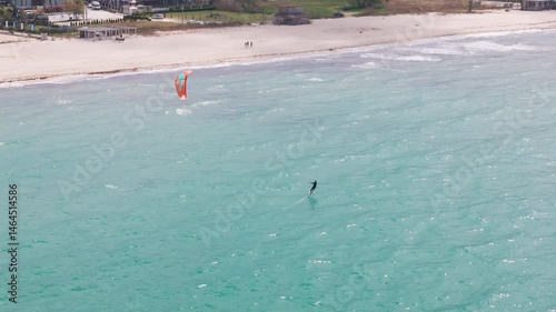 Epic Aerial View of Kitesurfer Riding Waves on Turquoise Sea